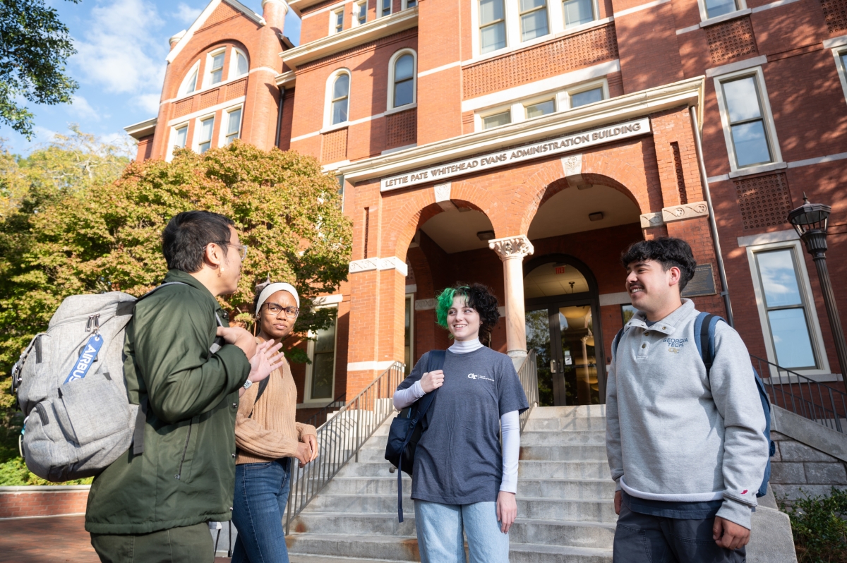 A group of students conversing in front of a building